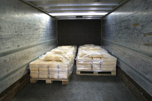 manufactured cheese on pallets in back of refridgerated truck